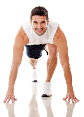Competitive male athlete ready to run - isolated over a white background